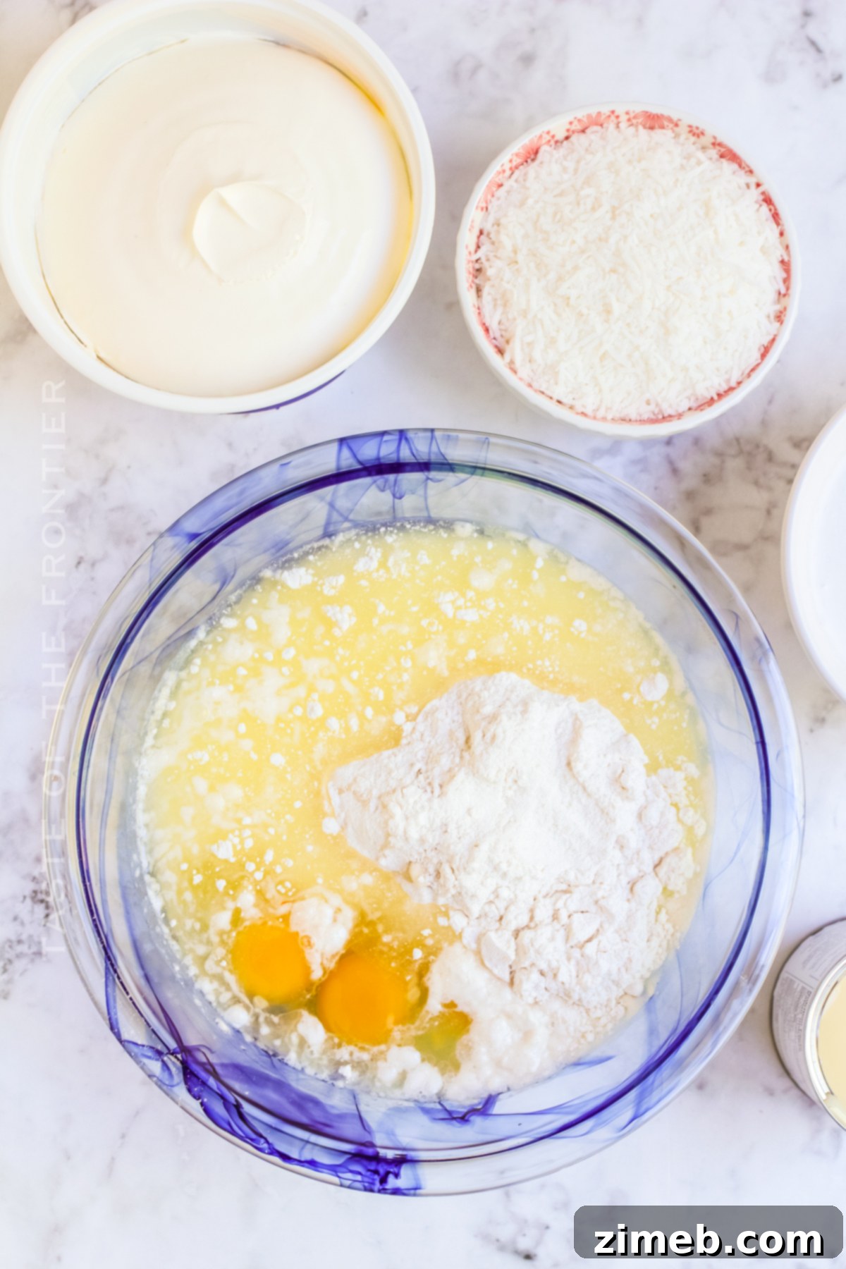 Making coconut cake batter in a bowl, showing the smooth consistency.