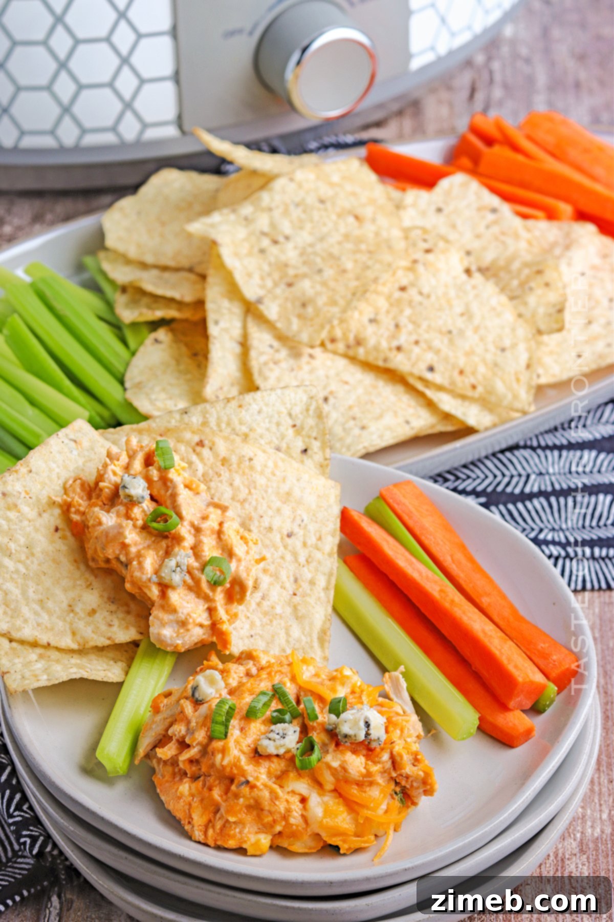 Crock-Pot Buffalo Chicken Party Dip 3 Cheesy Buffalo Chicken Dip simmering in a crockpot, showcasing its melted cheese and vibrant buffalo sauce, ready to be served.