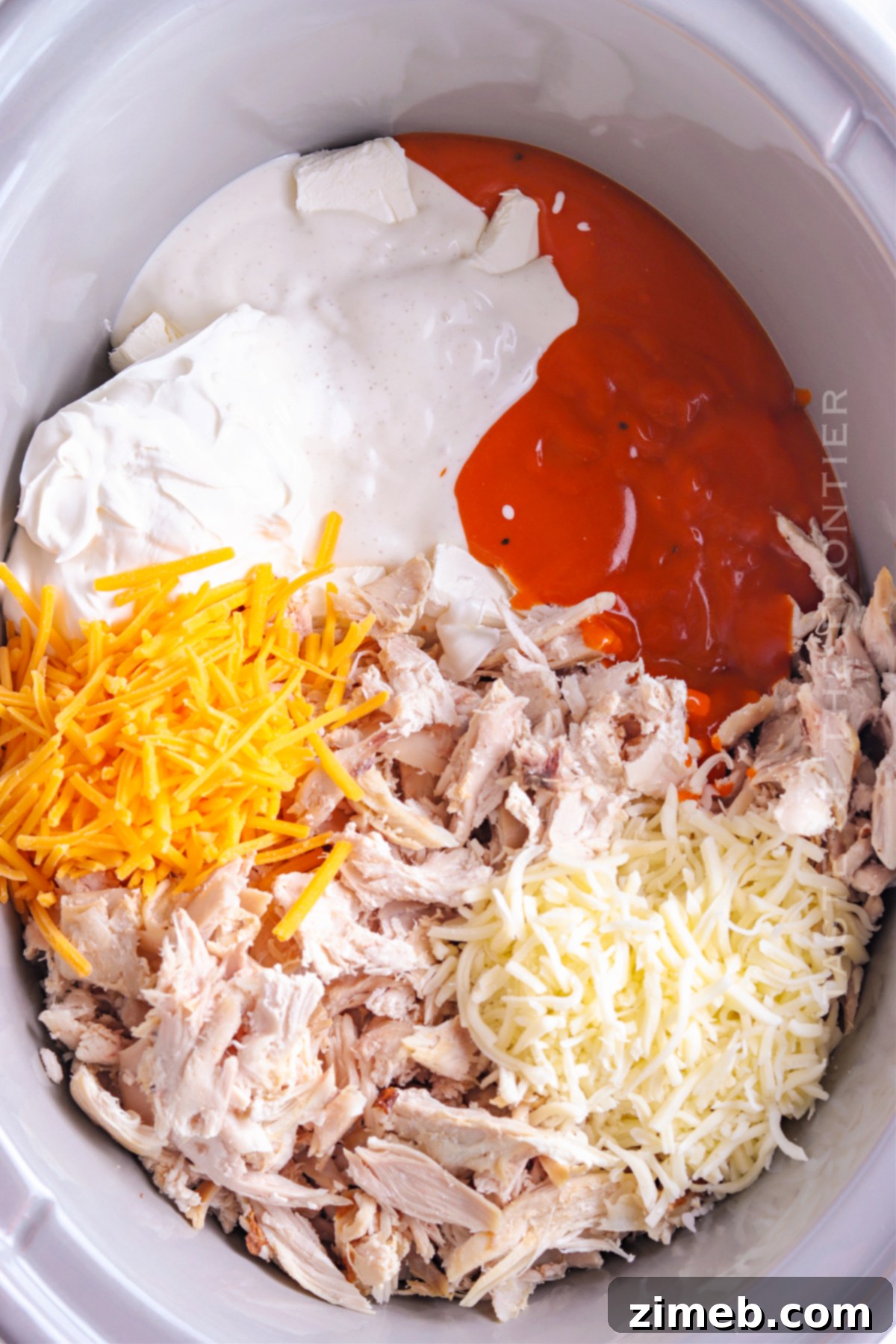 Crock-Pot Buffalo Chicken Party Dip 6 Close-up of creamy Chicken Wing Dip in a crockpot, topped with melted cheese and fresh green onions, ready for serving.