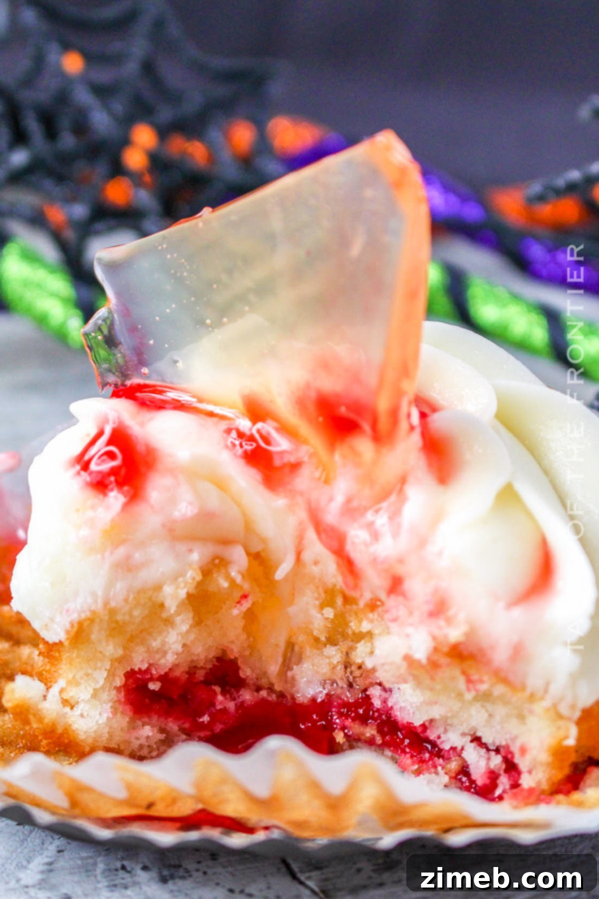 A bite of a Halloween cupcake showing the strawberry filling