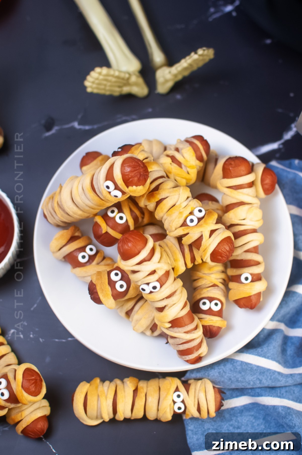 Phantom Franks 19 Air Fryer Mummy Dogs plated with dipping sauces, perfect Halloween appetizers.