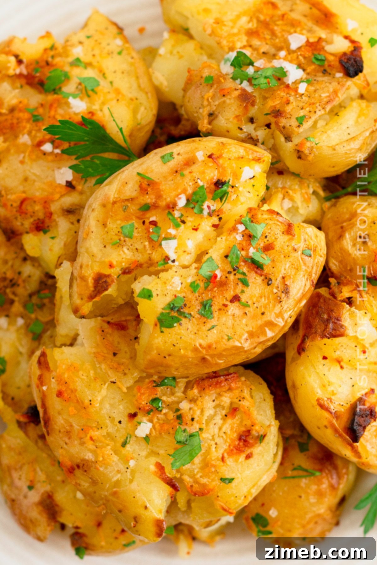 Crispy Smashed Potatoes 22 A final serving of perfectly cooked Smashed Potatoes, beautifully garnished with fresh herbs and a side of creamy dipping sauce.