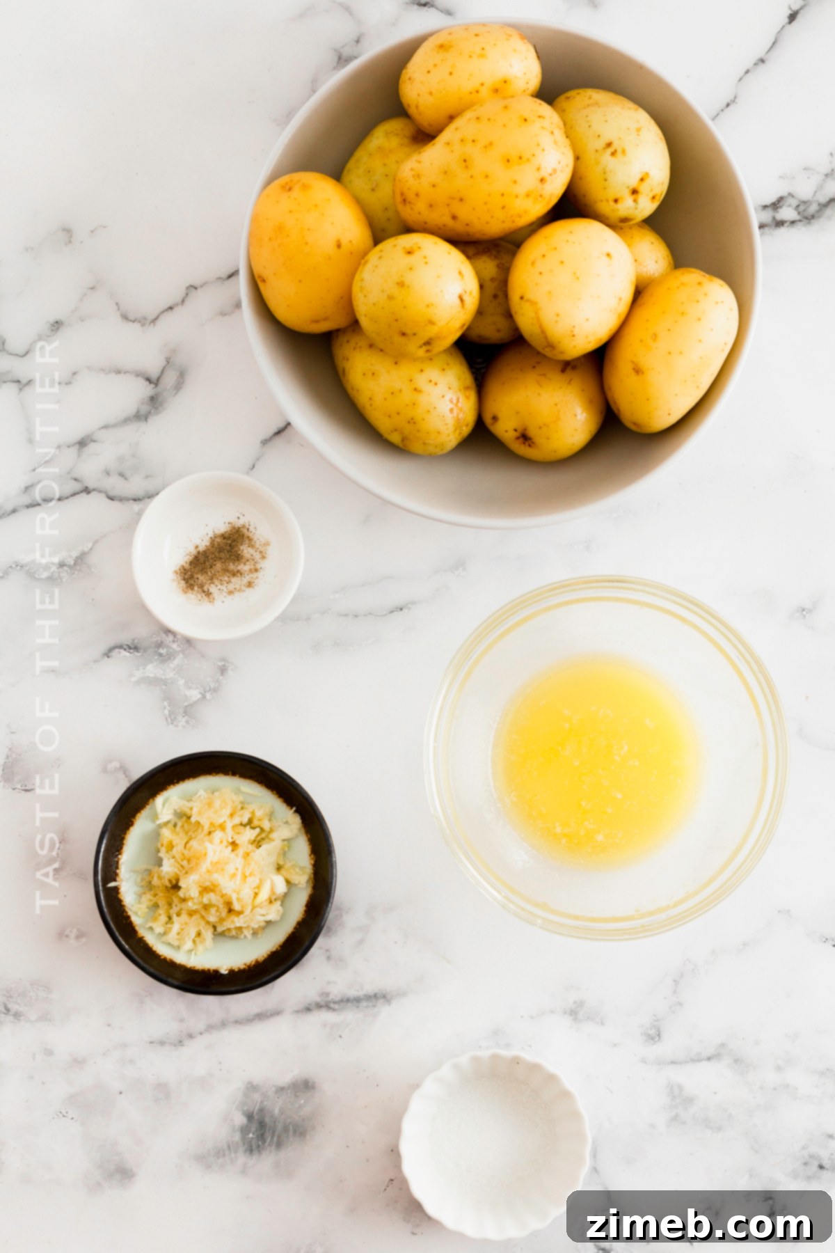 Crispy Smashed Potatoes 4 A vibrant selection of ingredients for making Smashed Potatoes, including baby potatoes, butter, fresh garlic, salt, and pepper.