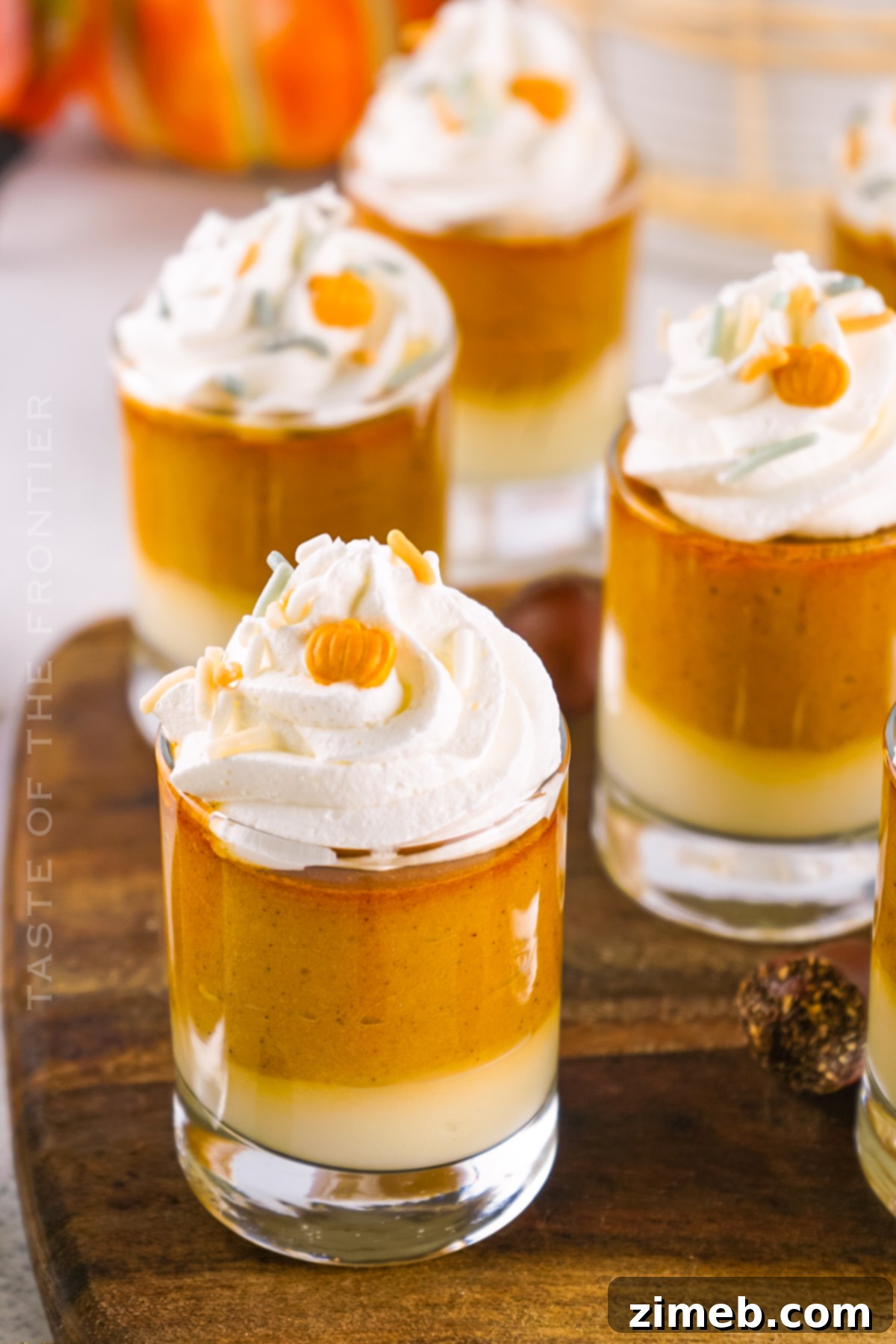 Boozy Thanksgiving Desserts featuring layered pumpkin and cheesecake pudding shots.