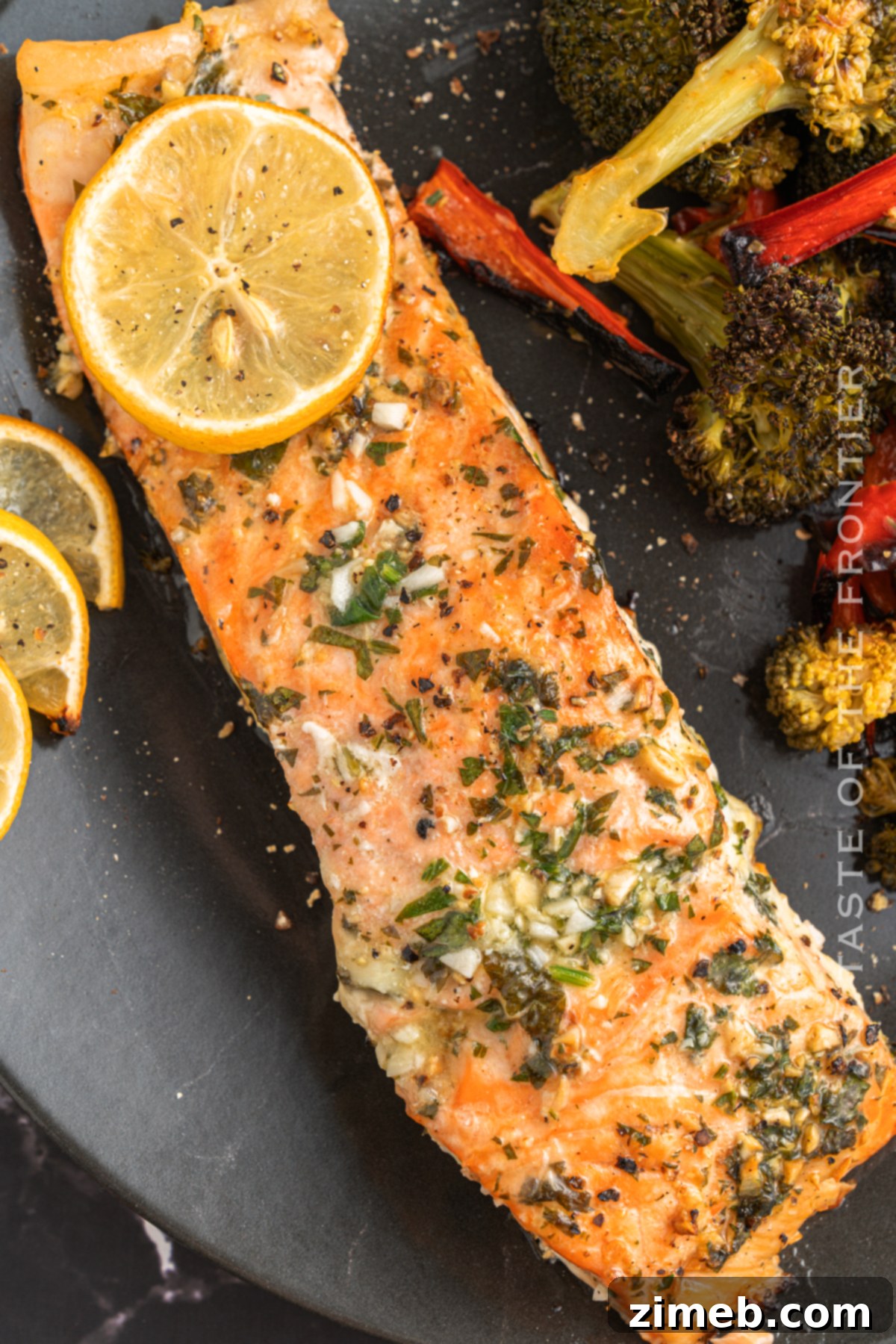 Garlic Butter Baked Salmon, flaked and ready to serve, showcasing its tender, juicy texture with fresh herbs.