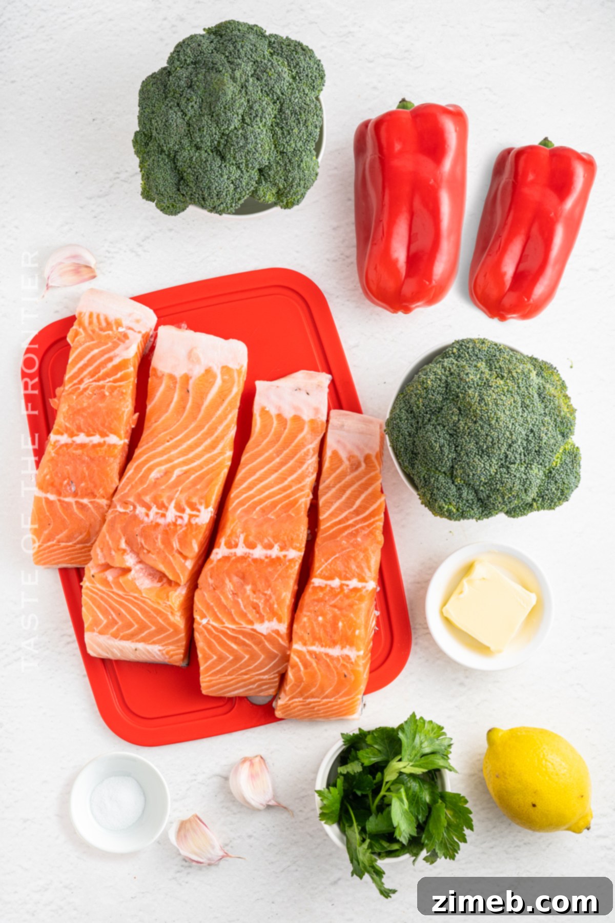 Ingredients for Baked Salmon laid out: salmon fillets, broccoli, red bell peppers, and a lemon, ready for preparation.