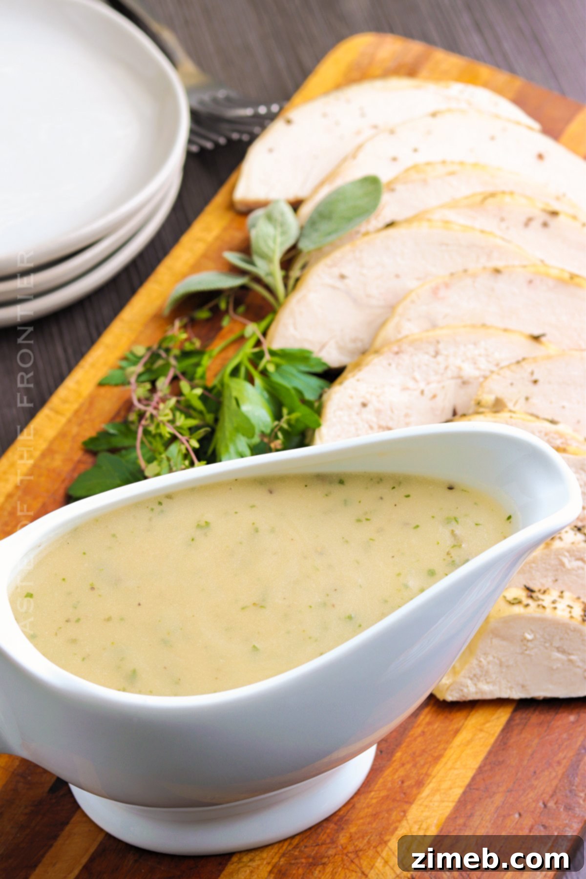 A beautiful ceramic gravy boat filled with rich, savory turkey gravy, ready for serving at a holiday meal.