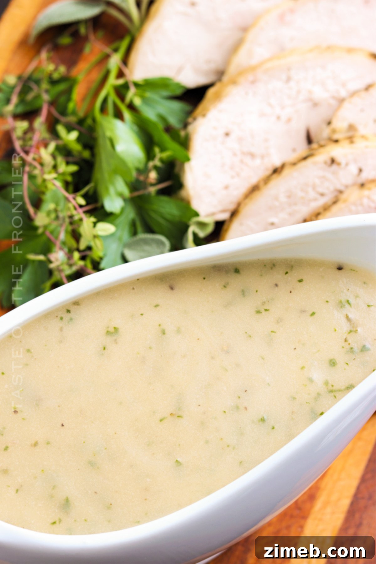 Close-up of rich, golden gravy made from turkey drippings in a rustic bowl, ready to be poured.