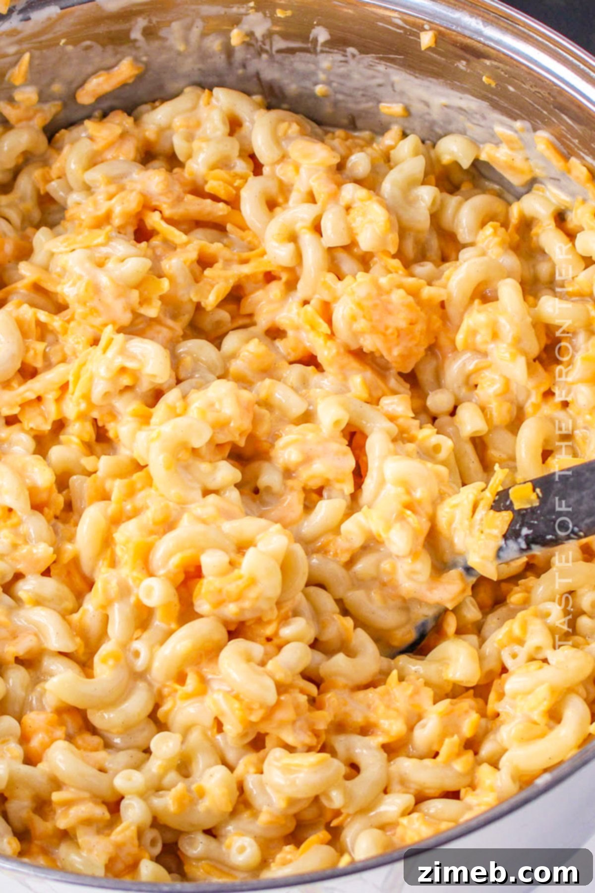 Ultimate Baked Mac and Cheese 6 Adding grated cheese to the macaroni mixture