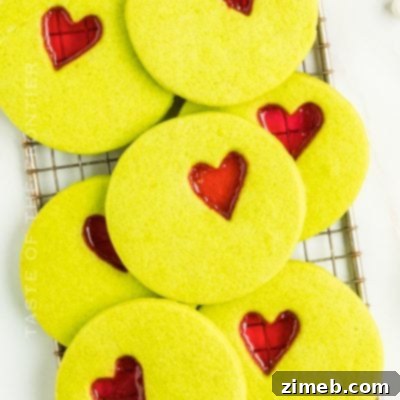 Recipe for Grinch Christmas Cookies, featuring green cookies with a red heart candy center.