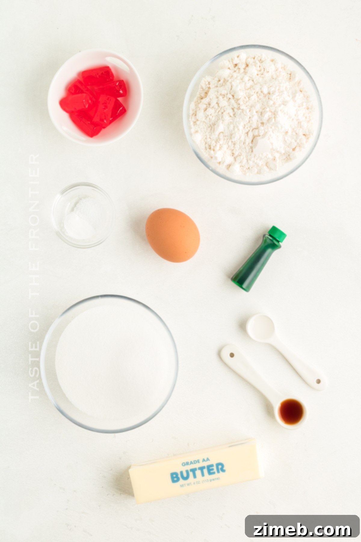 Ingredients for making festive Grinch Christmas Cookies, including flour, butter, sugar, and Jolly Ranchers.