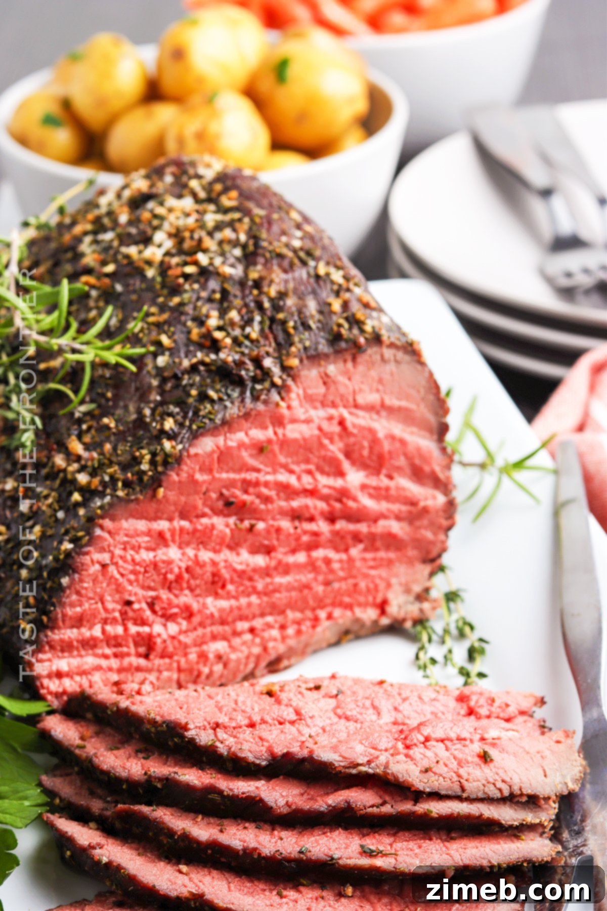 A beautifully presented holiday meat recipe: oven roast beef garnished with fresh herbs and served on a platter.