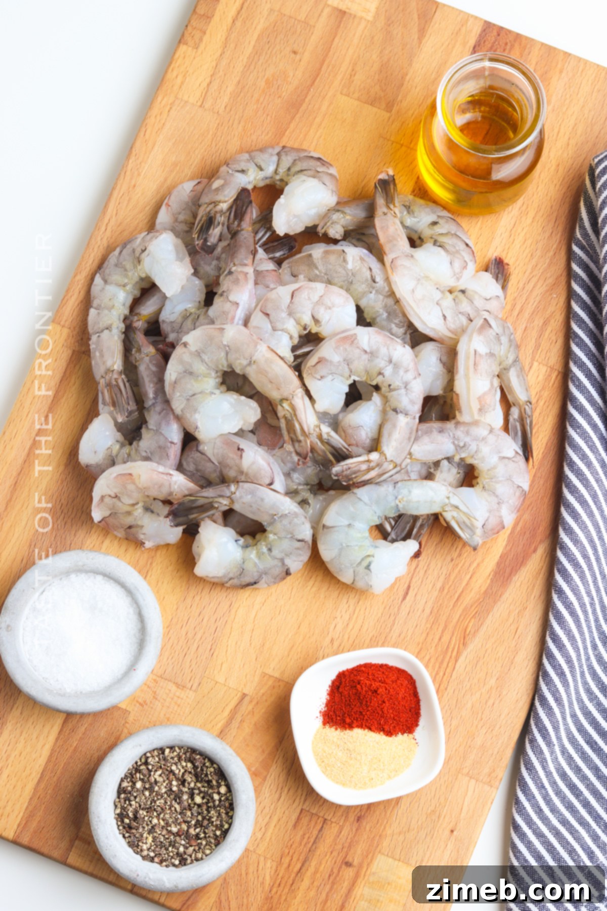 Savory Smoked Shrimp 4 Ingredients laid out for making delicious smoked shrimp: raw shrimp, vegetable oil, and a blend of spices.