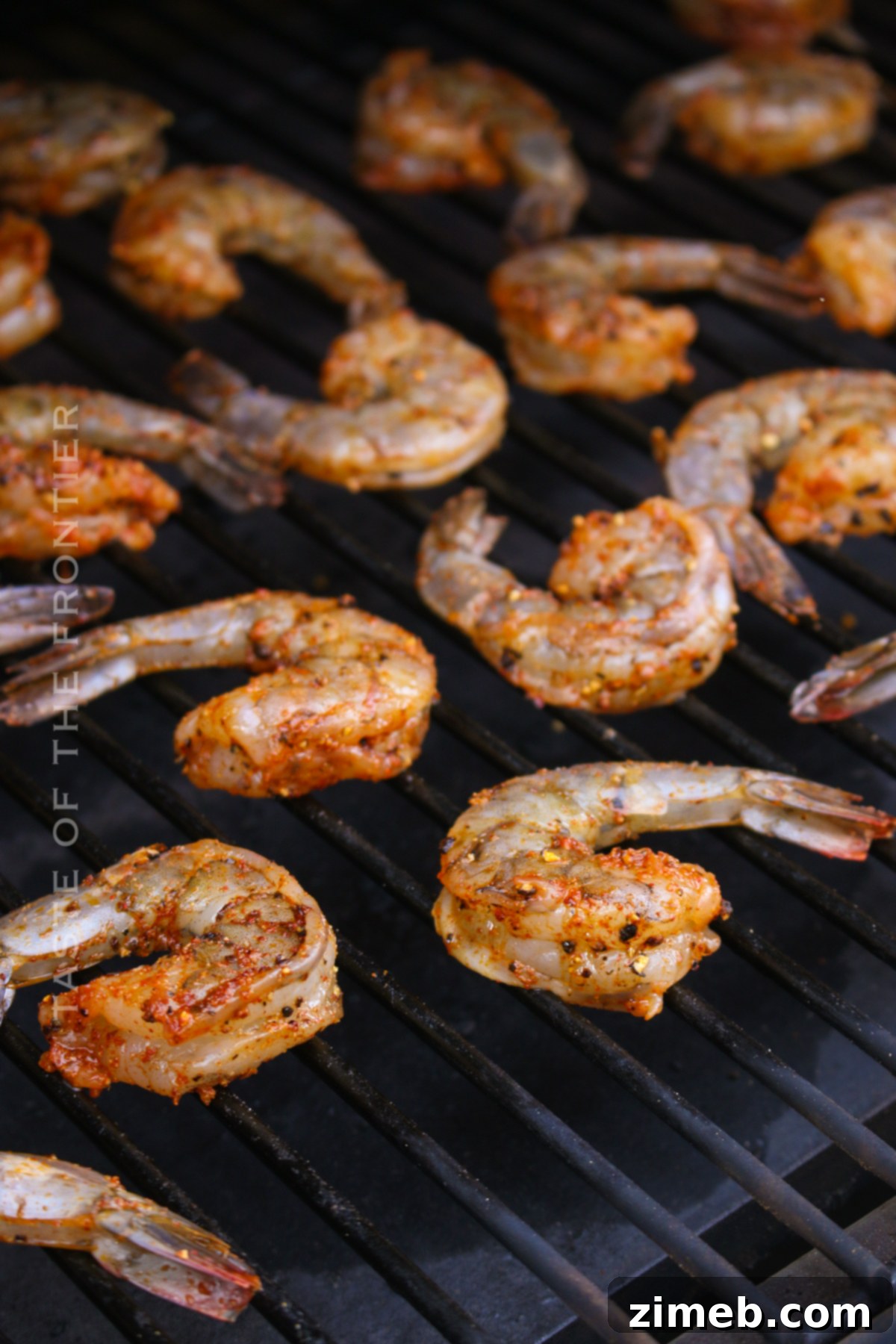 Savory Smoked Shrimp 6 Step-by-step image of placing seasoned shrimp onto a smoker grate, illustrating how to make smoked shrimp.