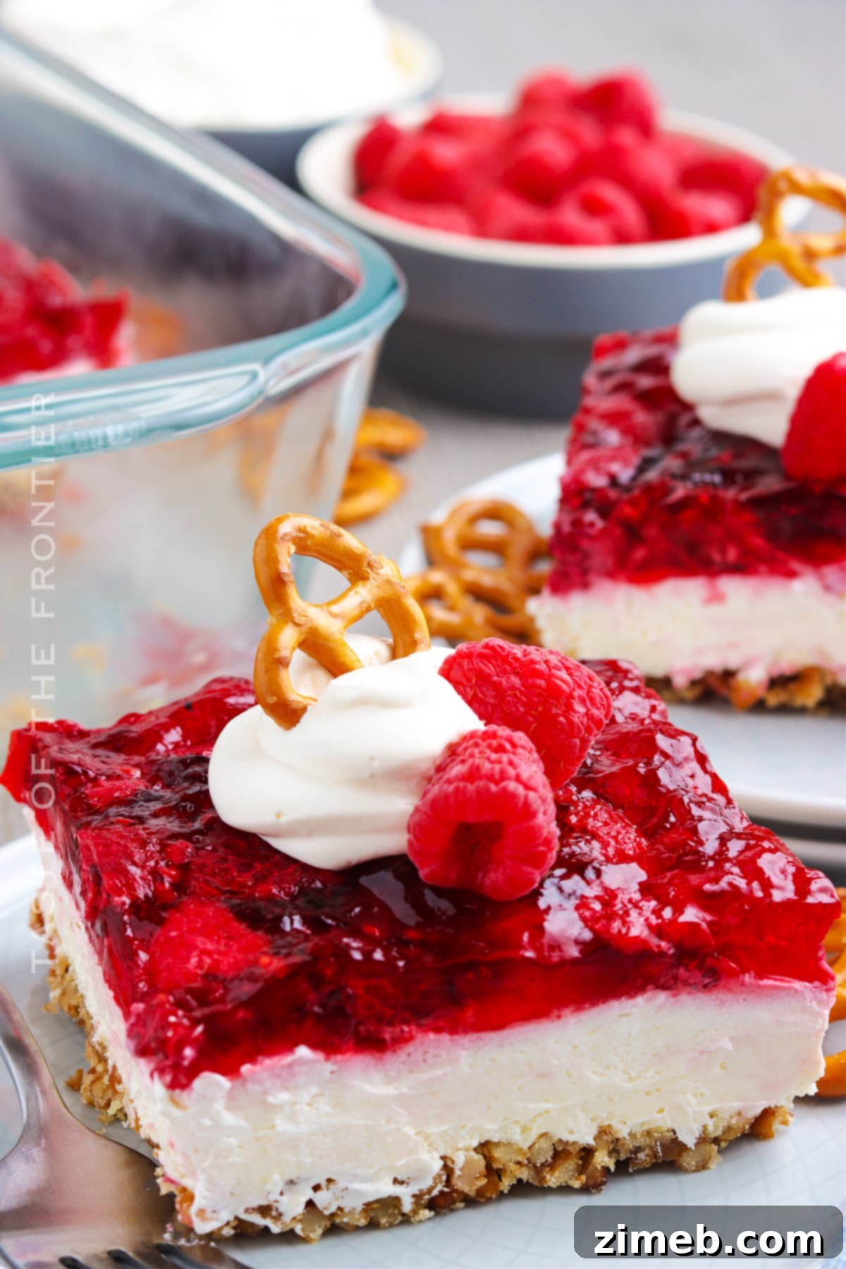 Salty Sweet Raspberry Dream 2 Classic Raspberry Pretzel Salad Recipe - A delightful layered dessert with a salty pretzel crust, creamy filling, and fruity jello top.