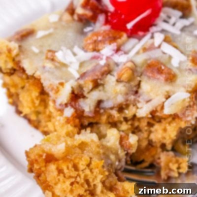 A slice of classic Fruit Cocktail Cake with cherries on top.