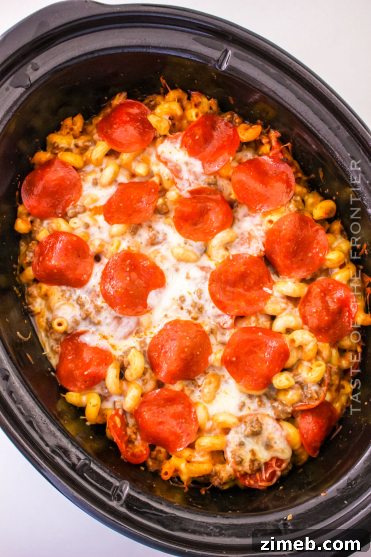 Cheesy Pizza Bake 6 Showing the process of how to make Pizza Casserole in the Crockpot, with cooked pasta and browned ground beef being combined.