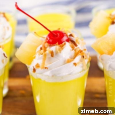 Creamy Pina Colada pudding shots garnished with toasted coconut.