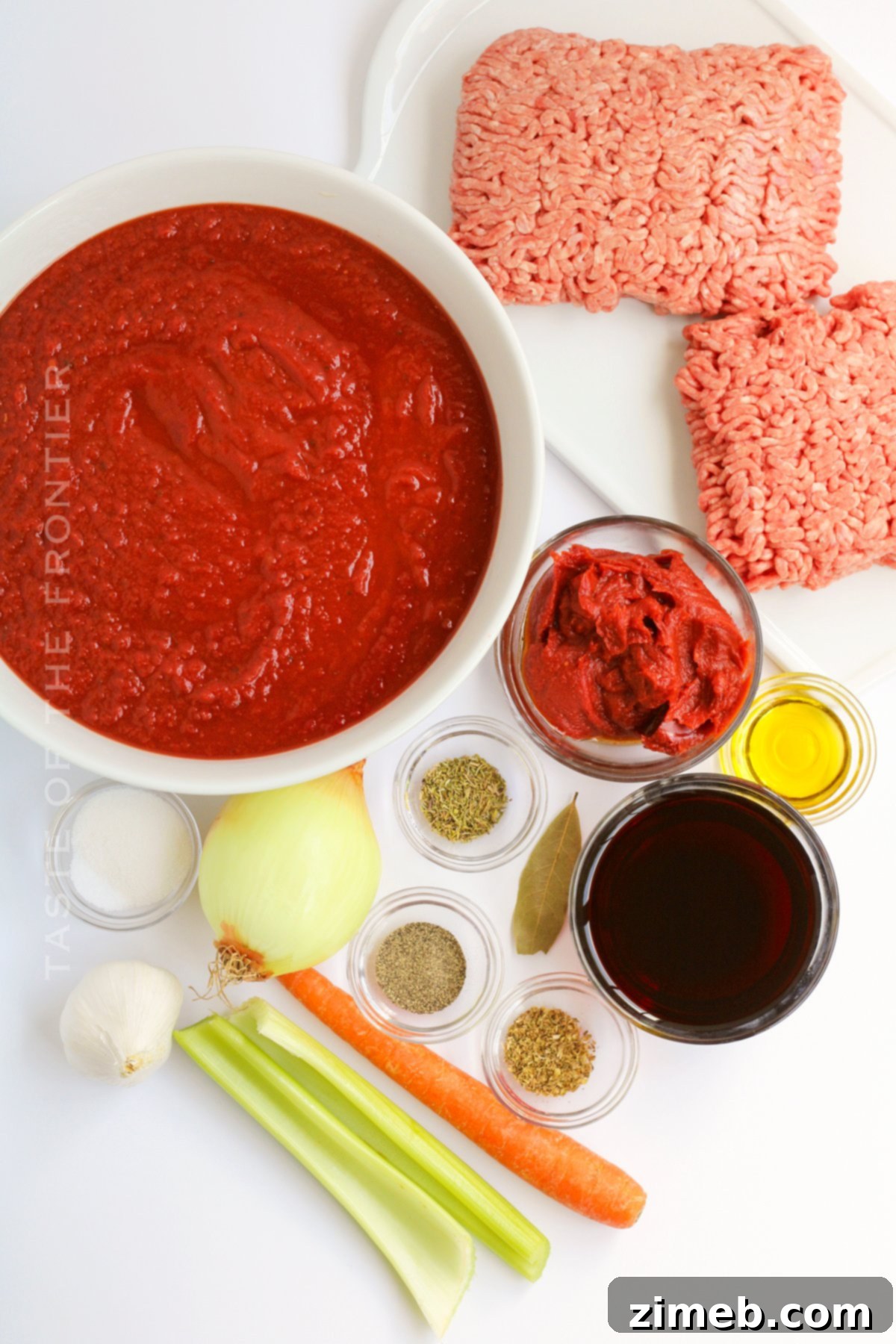 Effortless Weeknight Bolognese 4 Fresh ingredients laid out for an Easy Bolognese Recipe including vegetables, ground beef, and herbs.
