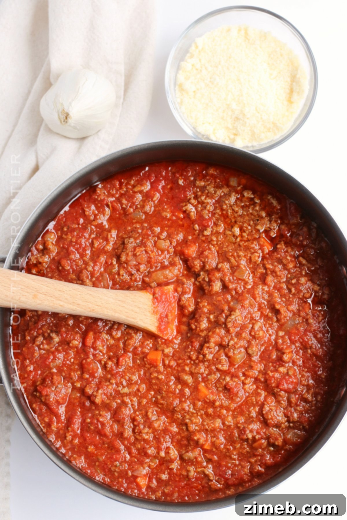Effortless Weeknight Bolognese 8 A serving of pasta topped with rich homemade meat sauce, garnished with fresh herbs.