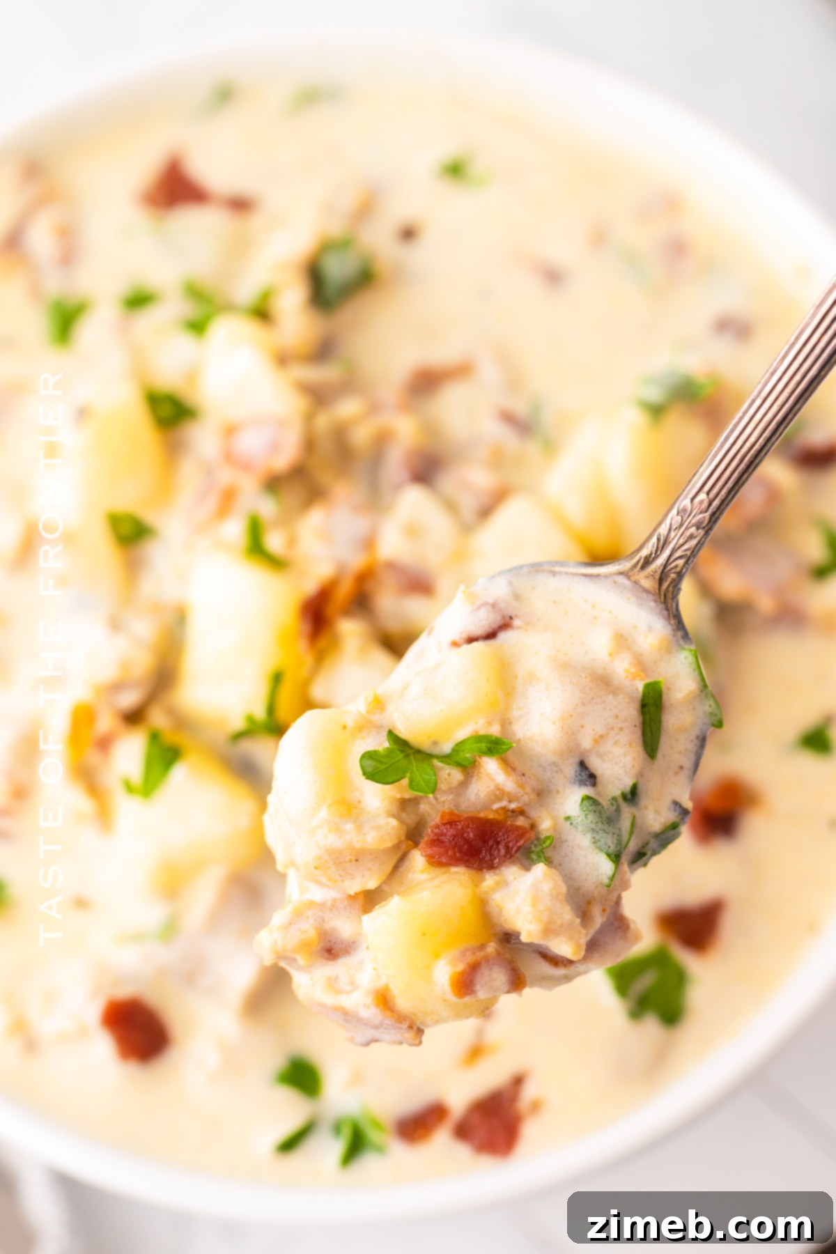 Boston-Style Clam Chowder 20 Creamy Bacon Clam Chowder garnished with fresh herbs in a bowl.