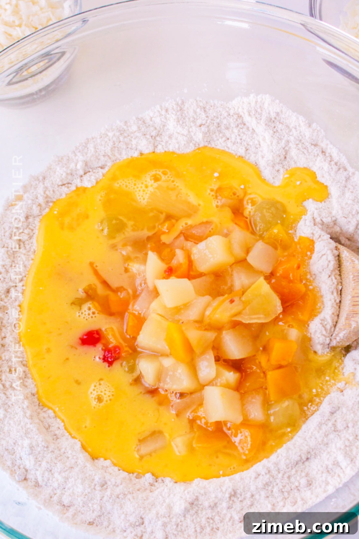 Pouring the can of fruit cocktail, undrained, into the cake batter.